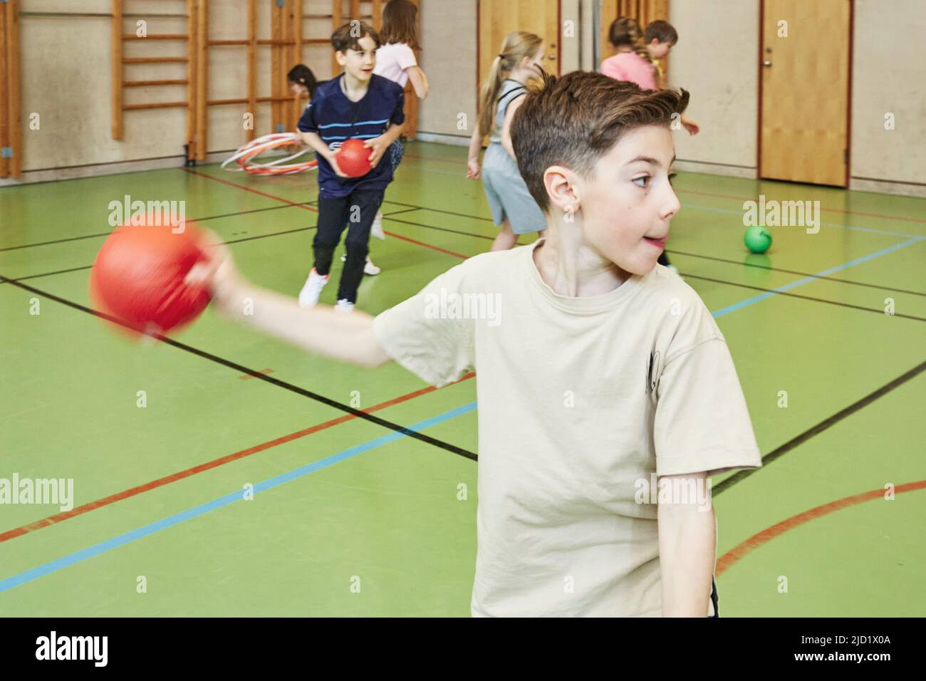 Boy throwing ball during PE class in school gym Stock Photo Alamy