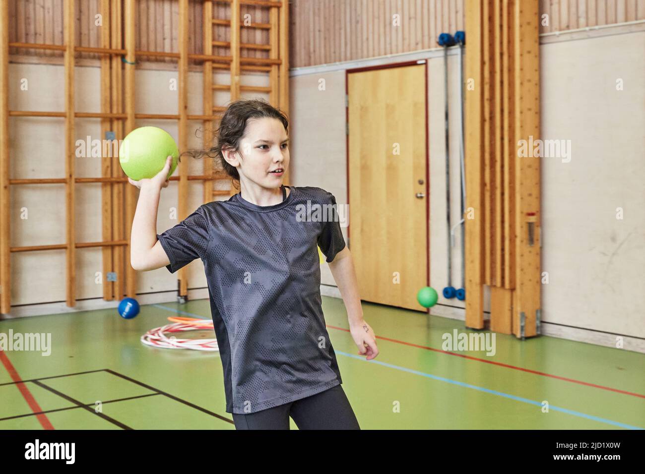 Girl throwing ball in PE class in school gym Stock Photo Alamy