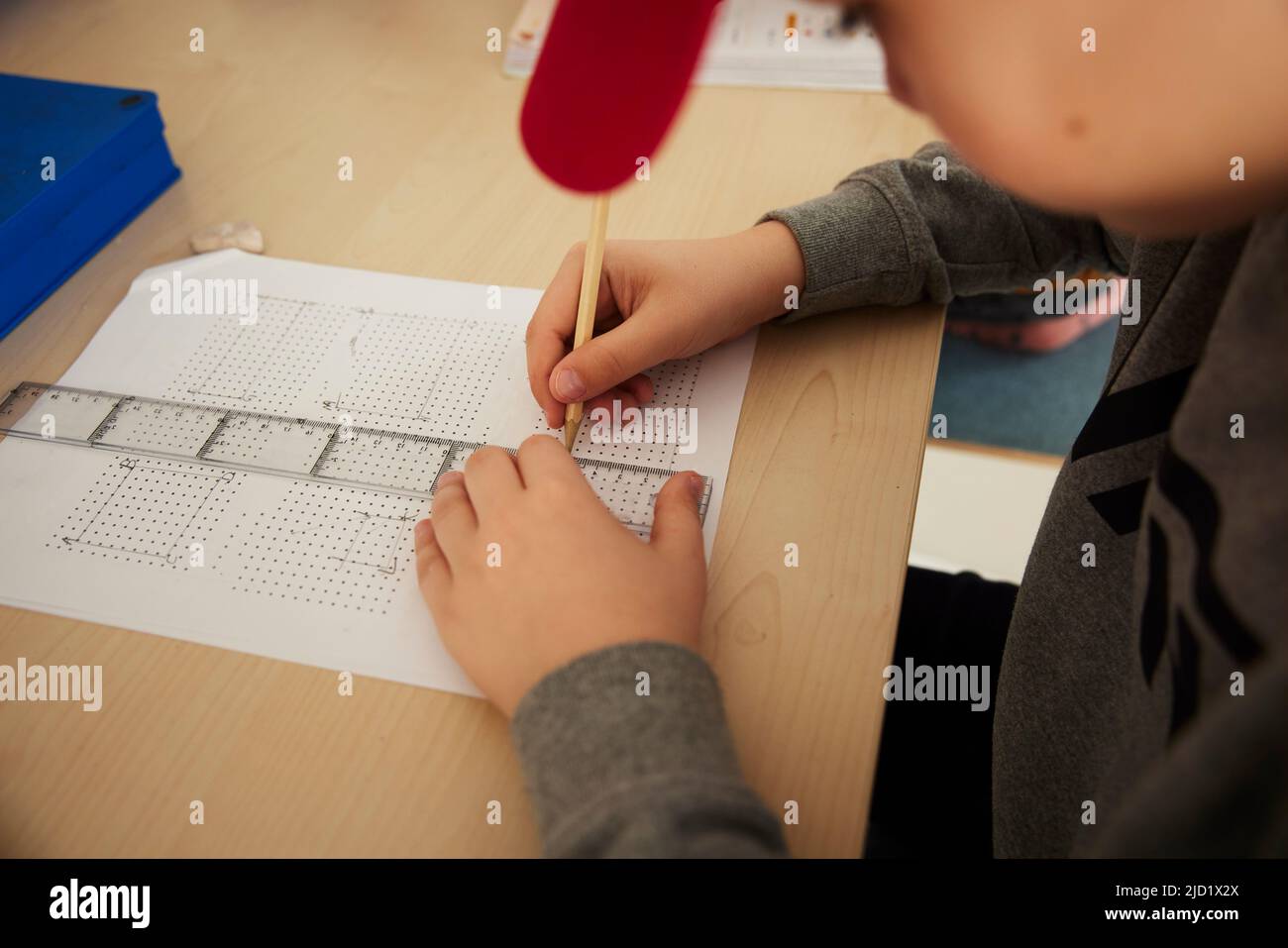 Boy using ruler and pencil at school Stock Photo