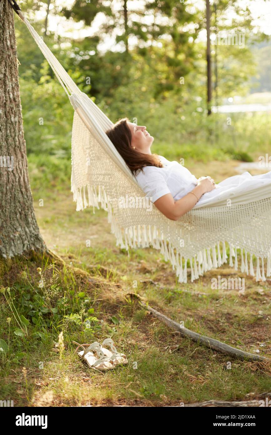 Woman relaxing in hammock Stock Photo - Alamy