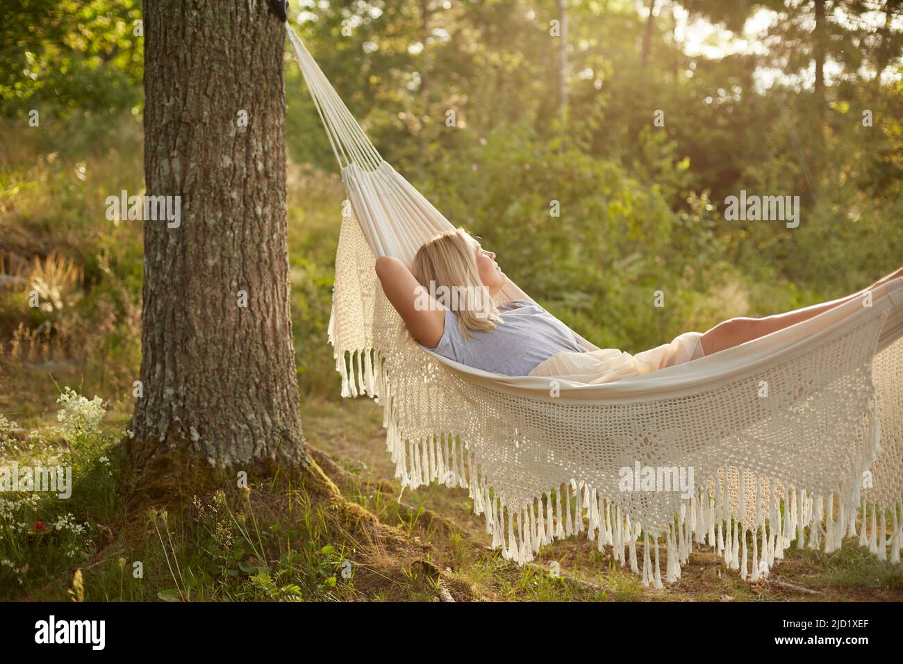 Woman relaxing in hammock Stock Photo - Alamy