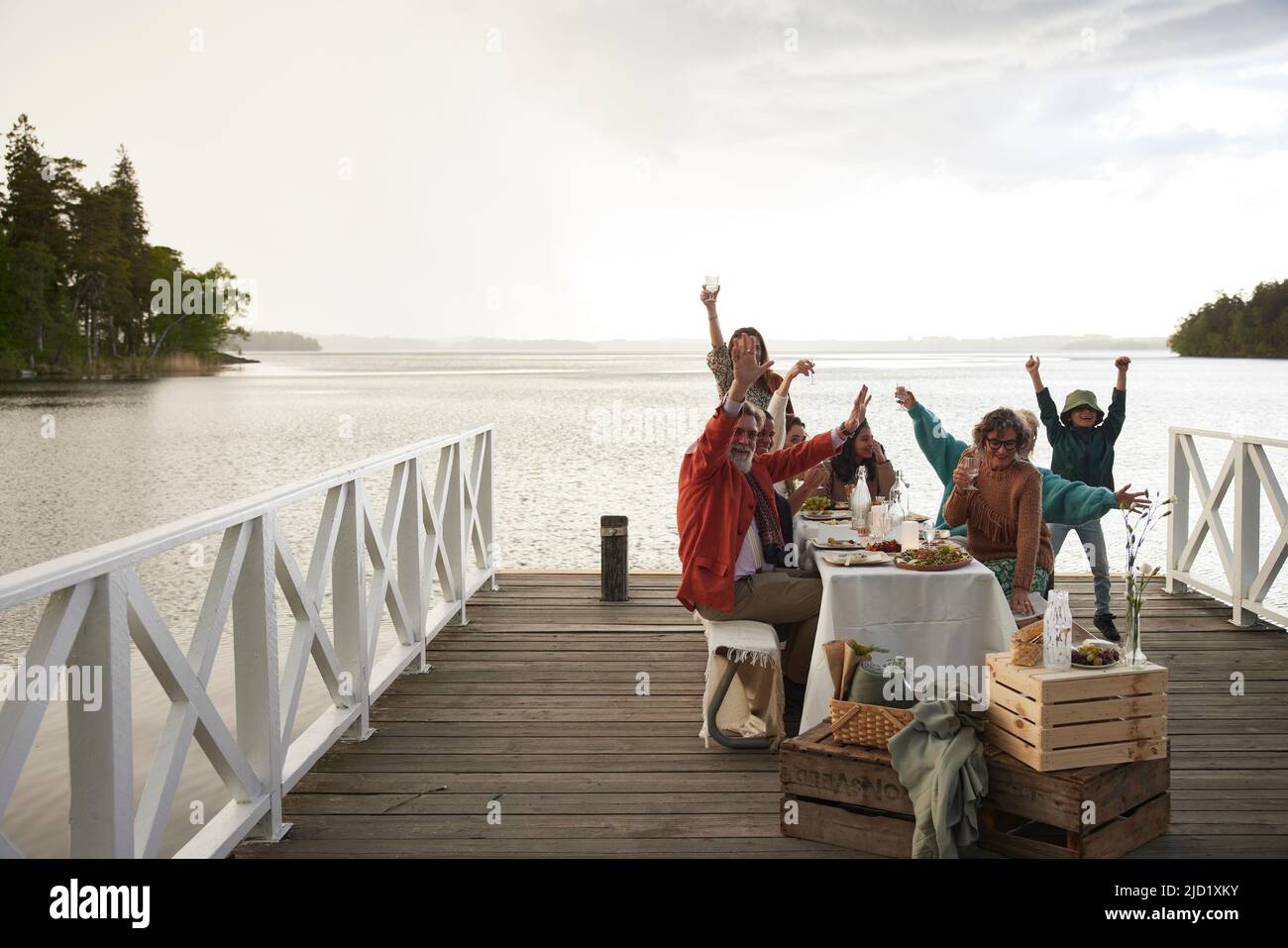 Family having dinner by lake and cheering Stock Photo