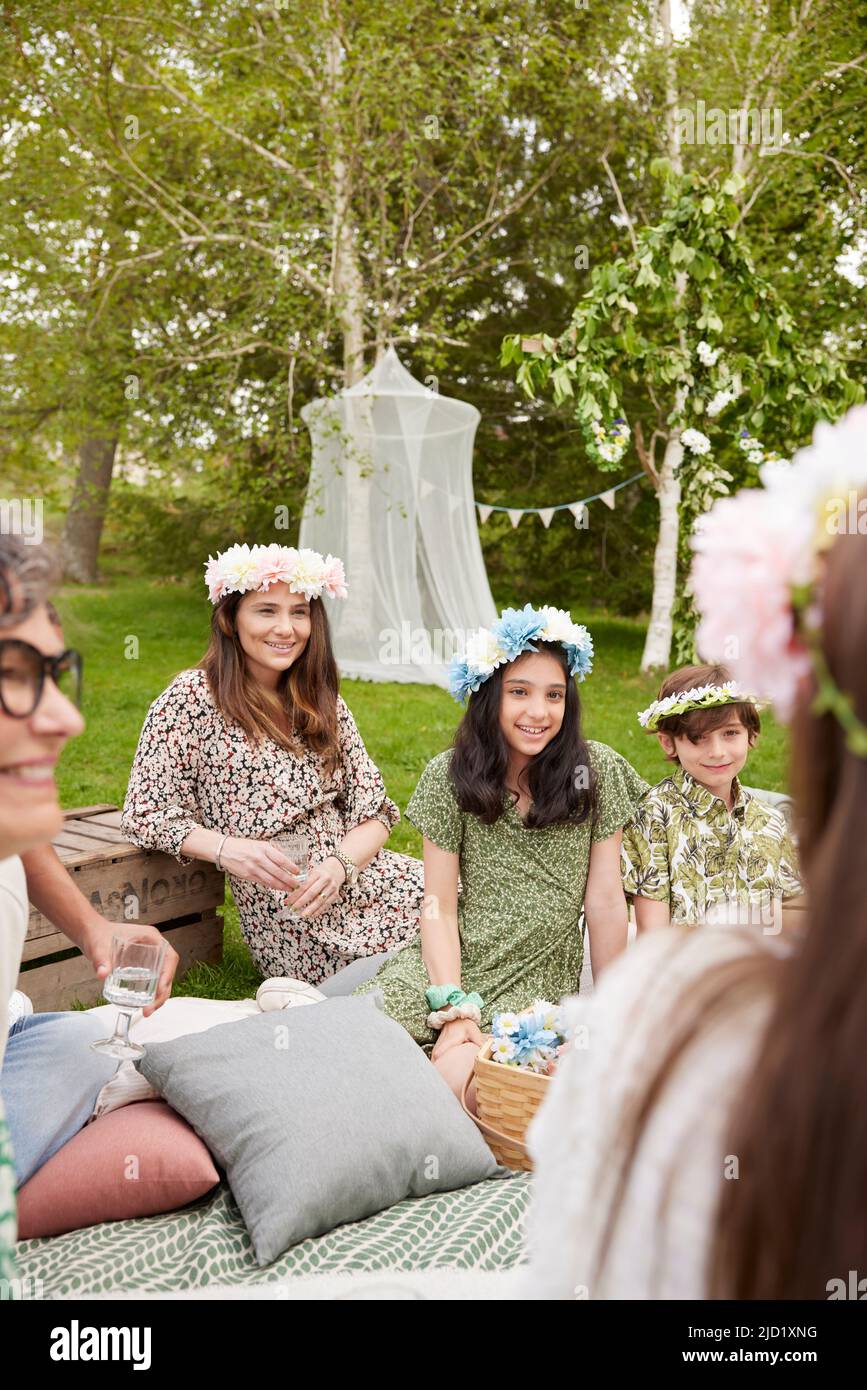 Family wearing flower wreaths at picnic Stock Photo