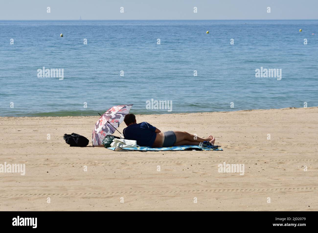 Boscombe, Bournemouth, Dorset, UK. 17th June, 2022. Weather. Set to be the hottest day of the year so far as the short heatwave peaks. A man finds space on the beach early in the morning. Credit: Paul Biggins/Alamy Live News Stock Photo