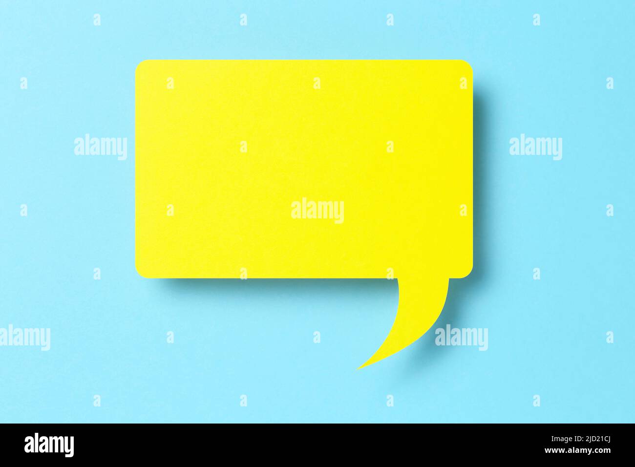 3d yellow paper speech bubble on blue Stock Photo