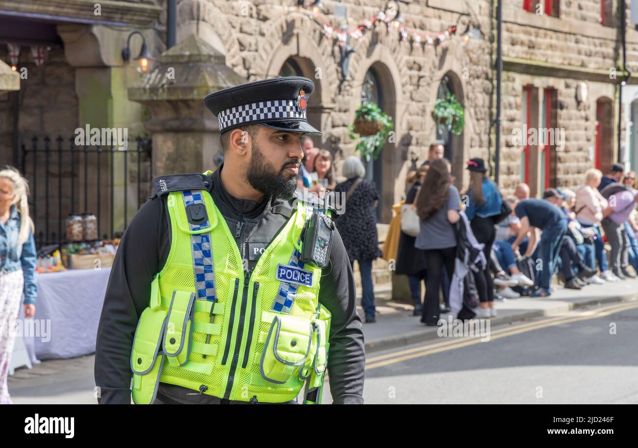 Young bearded crowd control policeman at the Uppermill Whit Friday Contest in Saddleworth, UK. Stock Photo