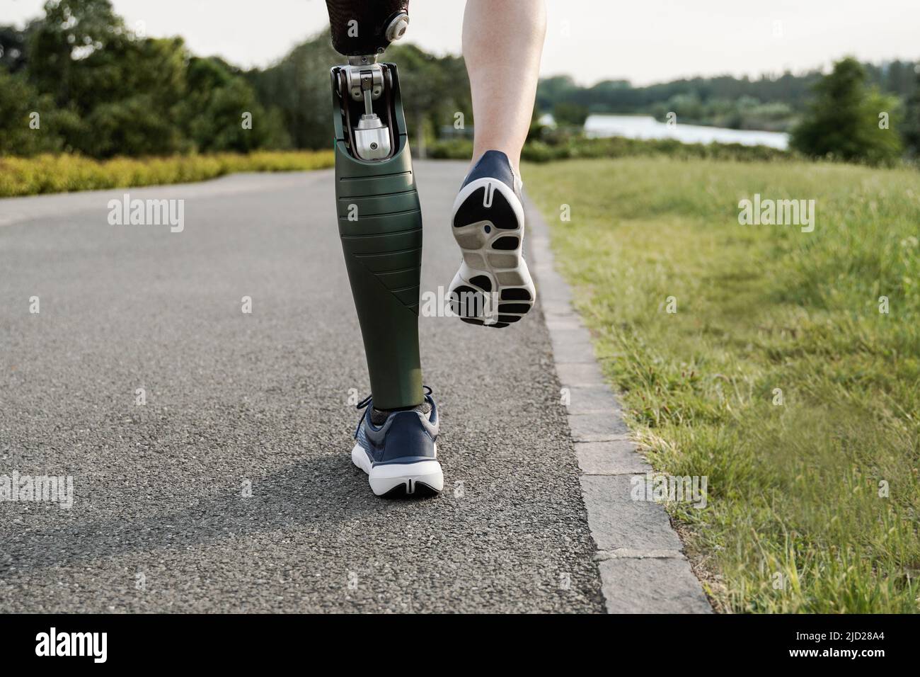 Sport man with prosthetic leg running training outdoor - Fitness and disability concept - Focus on prosthesis Stock Photo