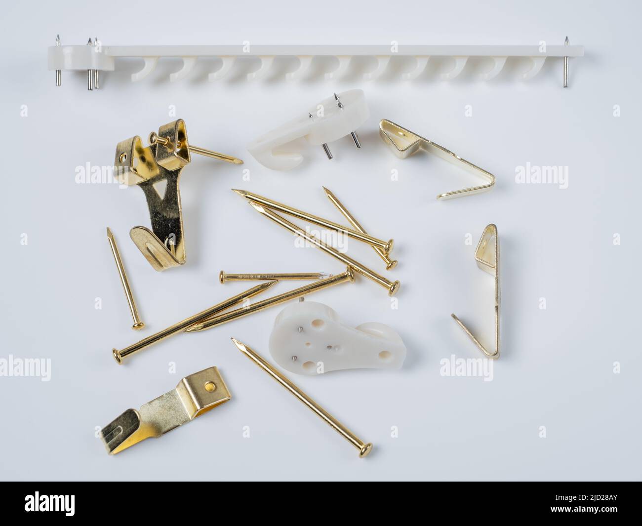 Picture frame wall hanging Accessory Kit of white nylon and gold brass hooks and brad nails Stock Photo