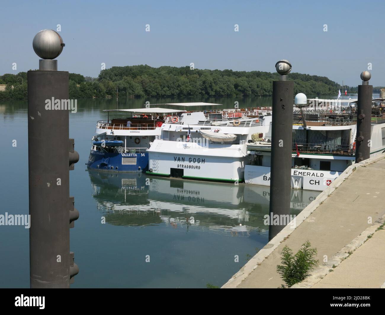 It is common practice on river cruises to moor three boats alongside each other and passengers must disembark across all three to reach the shore. Stock Photo