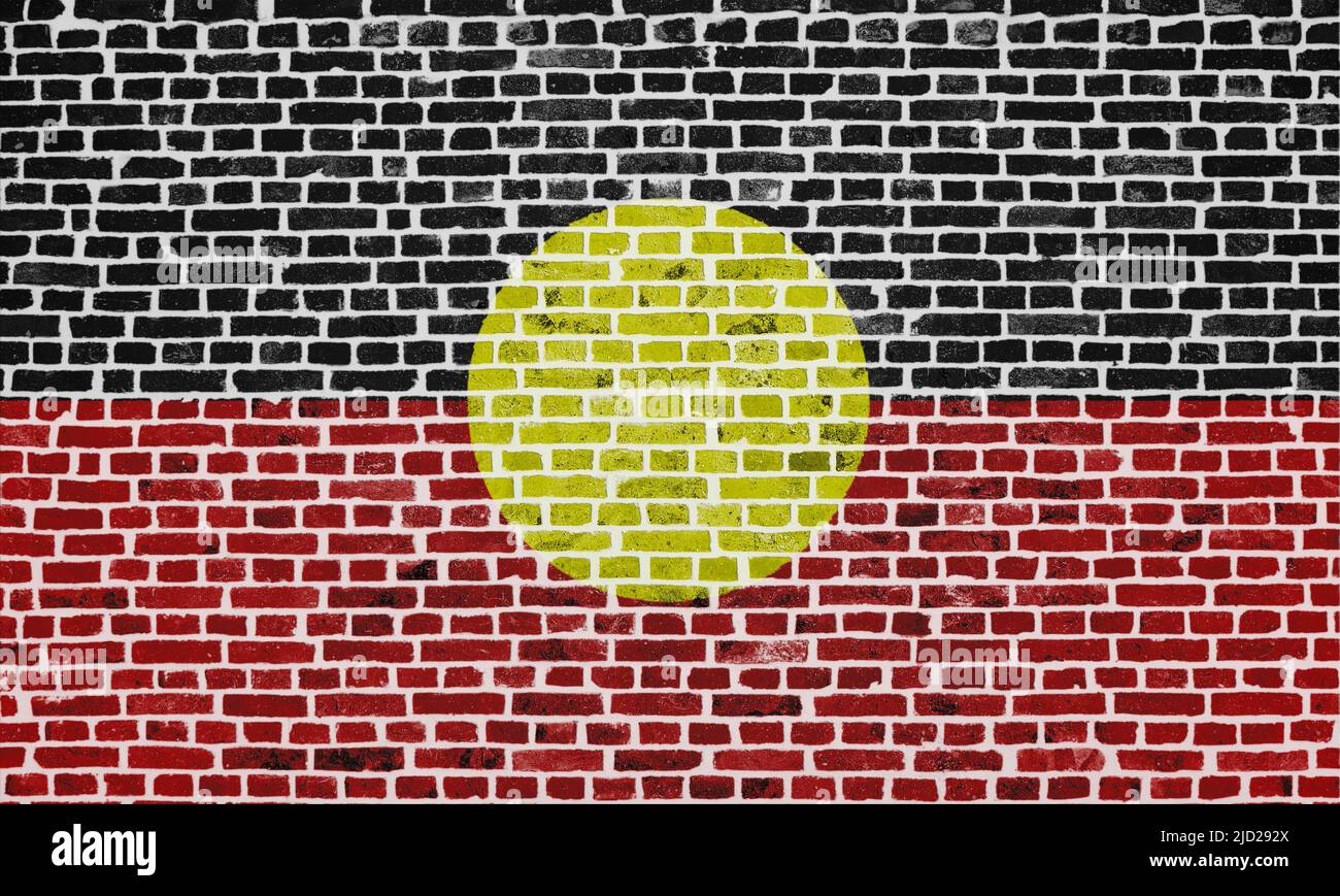 Close-up on a brick wall with the flag of Australian Aboriginal painted on it. Stock Photo
