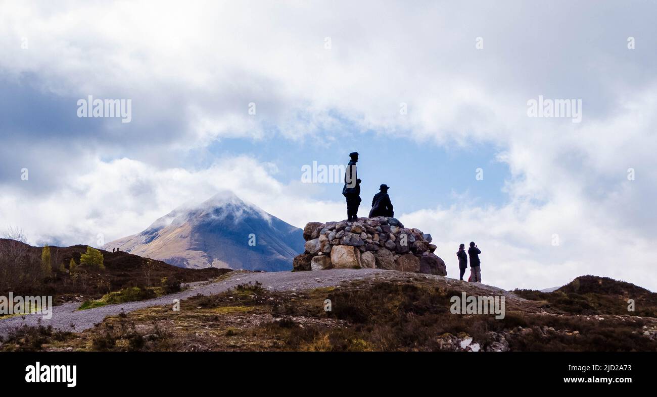 Miner statues with people admiring the view of the mountainous terrain, Isle of Skye, Scotland. Stock Photo