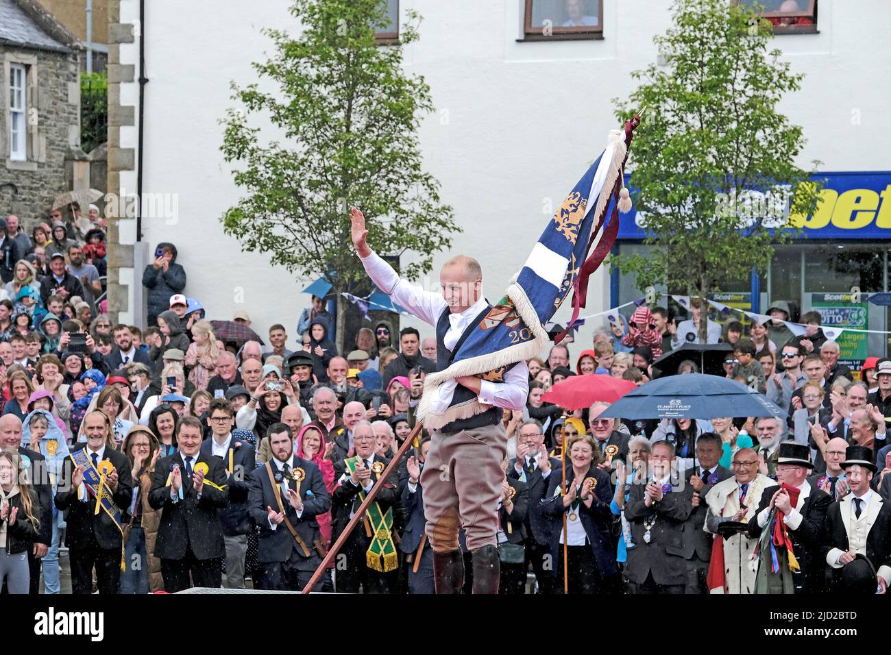 Royal Burgh Standard Bearer, Adam Nichol casting the Burgh Standard. Casting of the Colours takes place during the town's Common Riding, one of the oldest Borders festivals, on June 17, 2022 in Selkirk, Scotland. The event dating from the Battle of Flodden in 1513, remembers the story of Flodden, when Selkirk sent 80 men into battle with the Scottish King. One man returned, bearing a blood stained English flag.The climax of the day involves the town's Standard Bearer and Crafts and Associations Standard Bearers casting their colours in Selkirk's Ancient Market Place. (Photo: Rob Gray) Stock Photo
