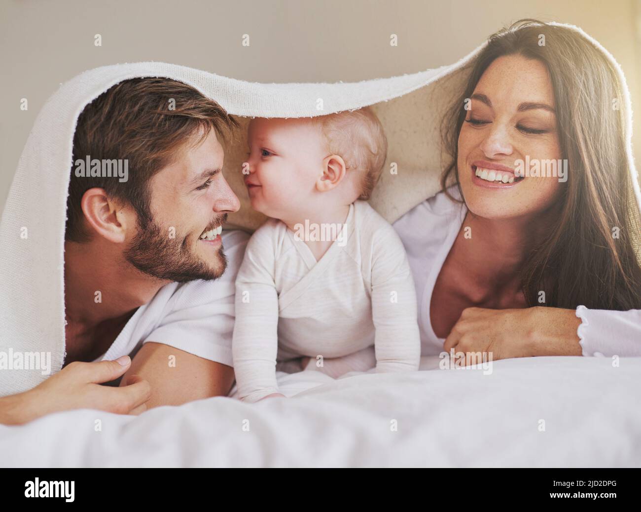 Shes daddys little girl. Cropped shot of a young couple and their baby daughter in the bedroom. Stock Photo