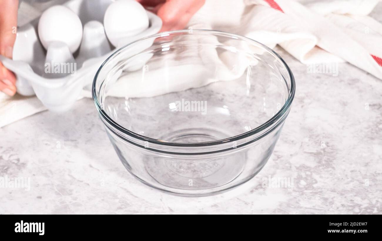 Step by step. Mixing ingredients in a glass mixing bowl to prepare