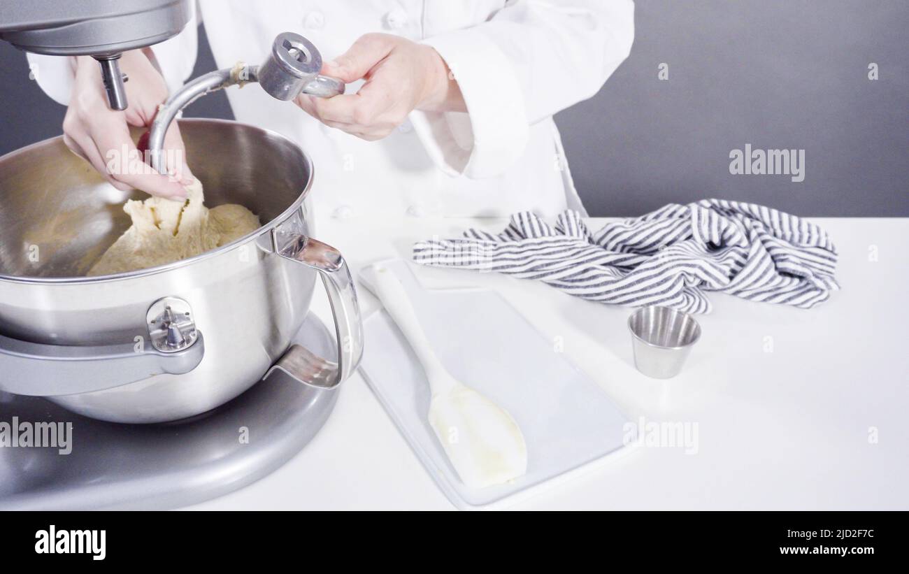 Mixing ingredients in a kitchen standing mixer to bake cinnamon rolls
