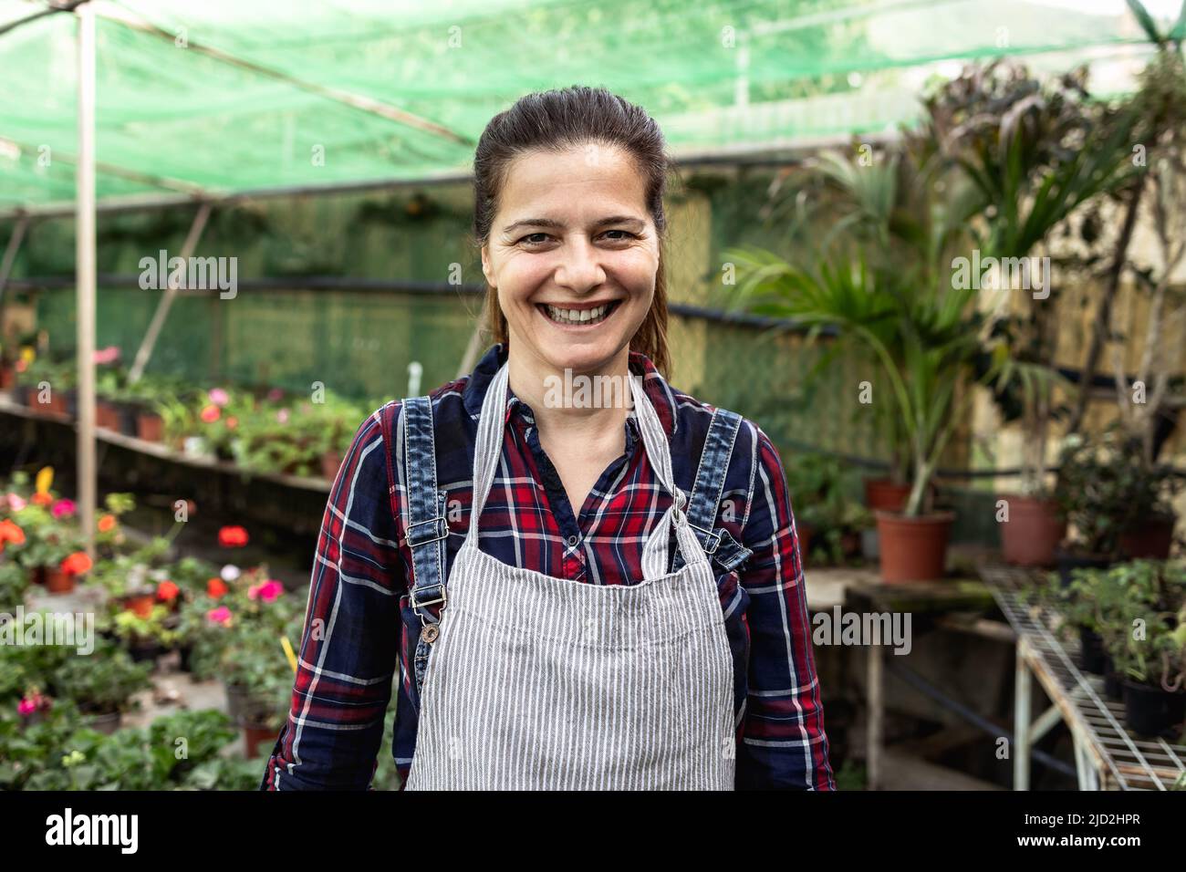 Happy smiling woman working in flower garden shop Stock Photo