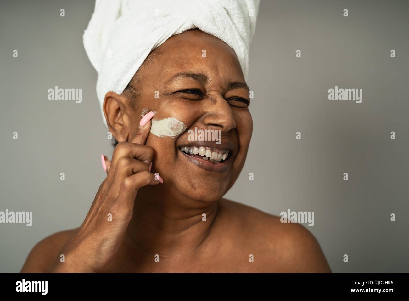 Happy African senior woman having skin care spa day - People wellness lifestyle concept Stock Photo