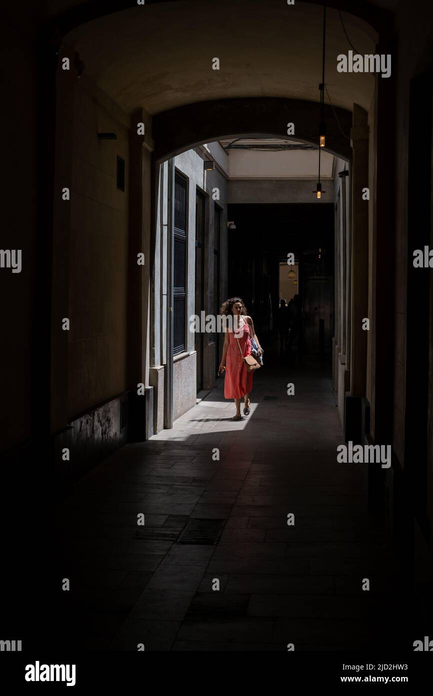 A lady walking through a shopping arcade in Barcelona, Spain. Stock Photo