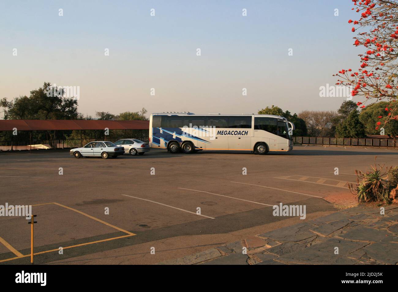 Megacoach bus, silver BMW and blue nissan vehicles parked in parking lot of the Voortrekker