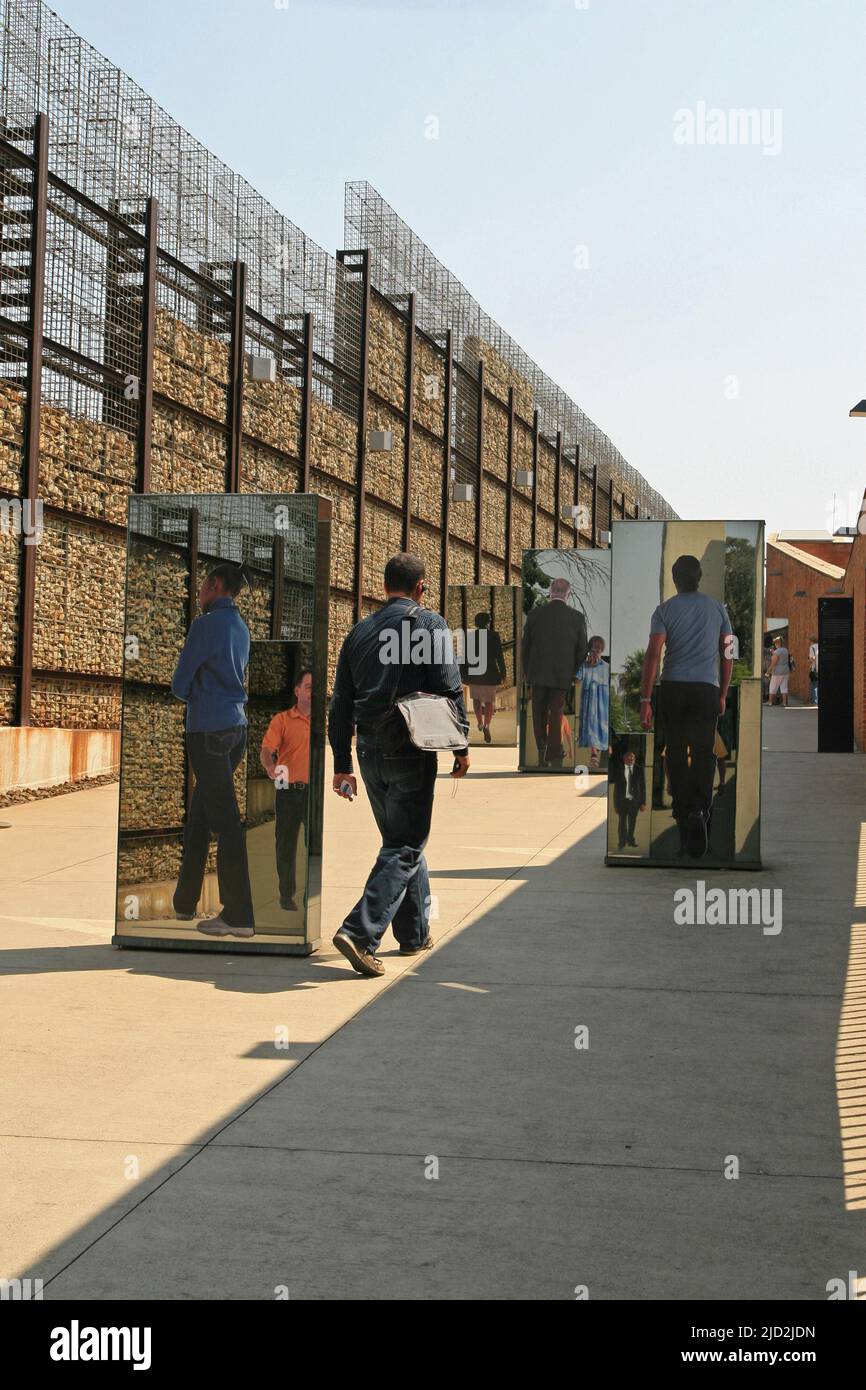Exhibit mirrors within wall of outdoor Apartheid Museum, Johannesburg