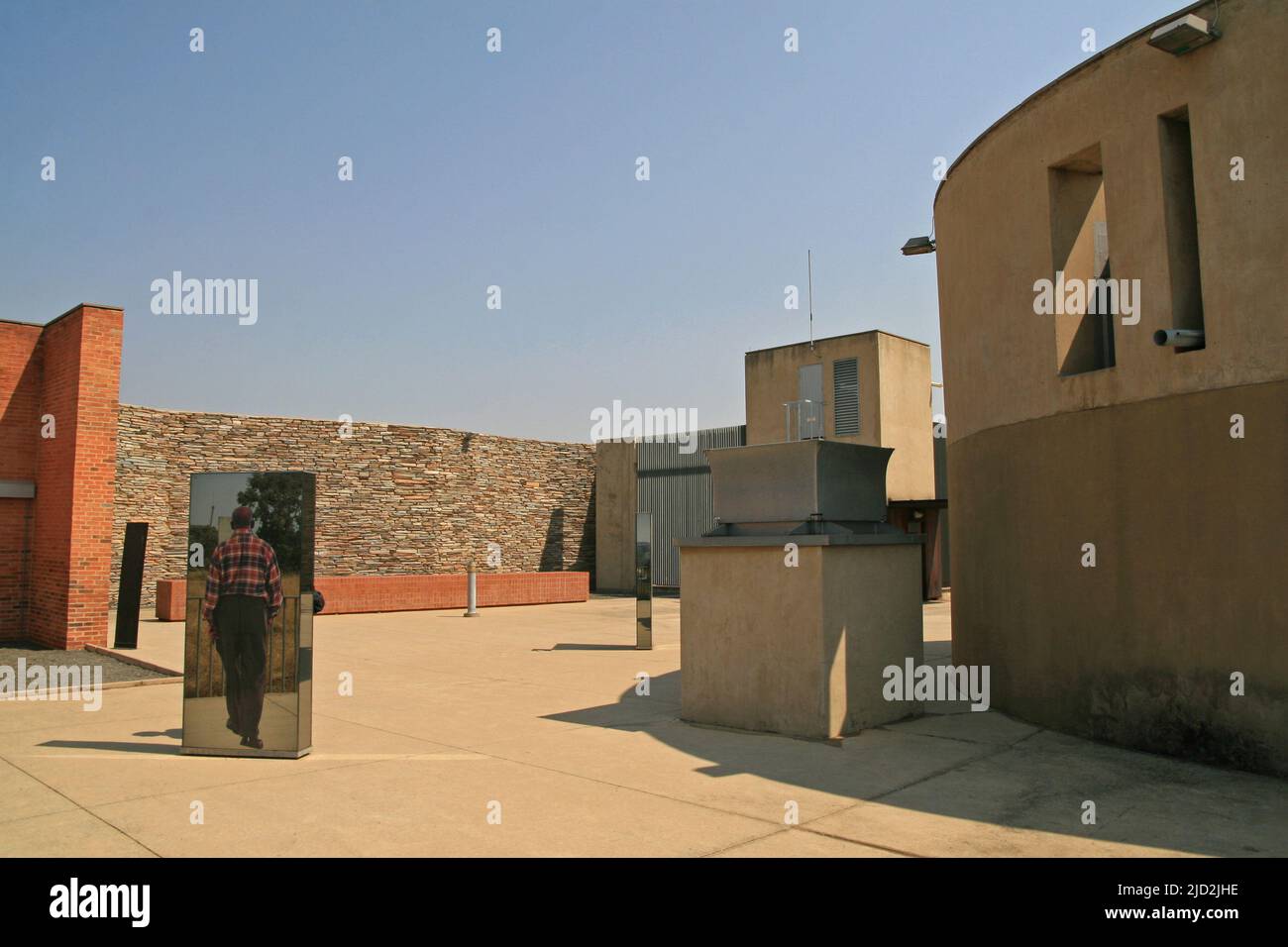 Exhibit mirrors area, stone wall of outdoor Apartheid Museum