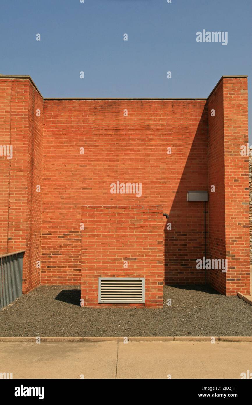 Brick wall and vent block at the edge of the exhibit mirrors area of