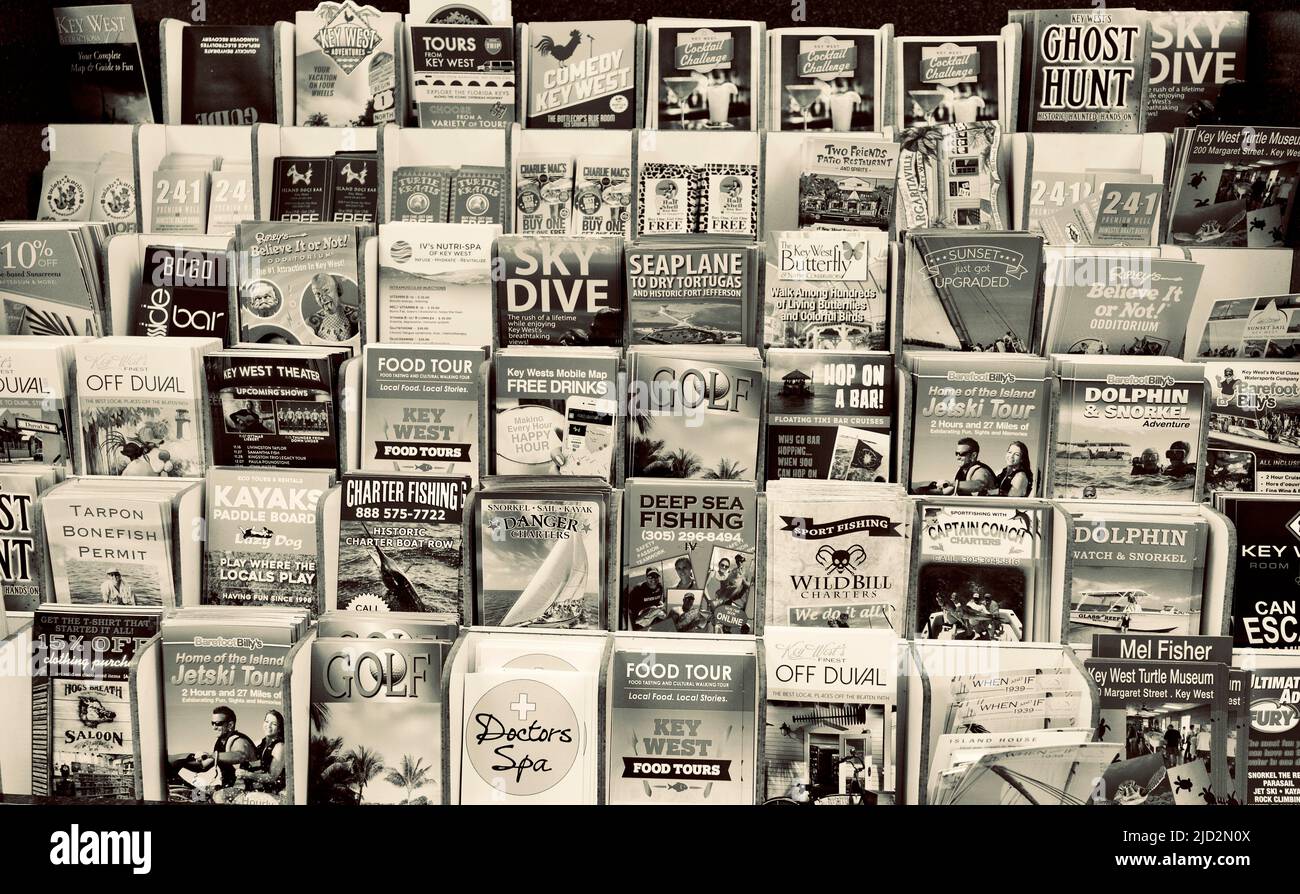 Tourist advertising brochures at  the Key West International Airport building.  Stacks of vertical brochures for various destinations or activities. Stock Photo