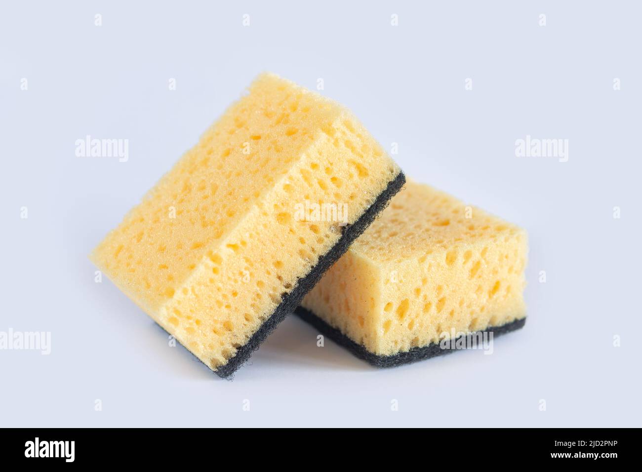 Two yellow sponges for washing dishes and other domestic needs on white background close-up Stock Photo