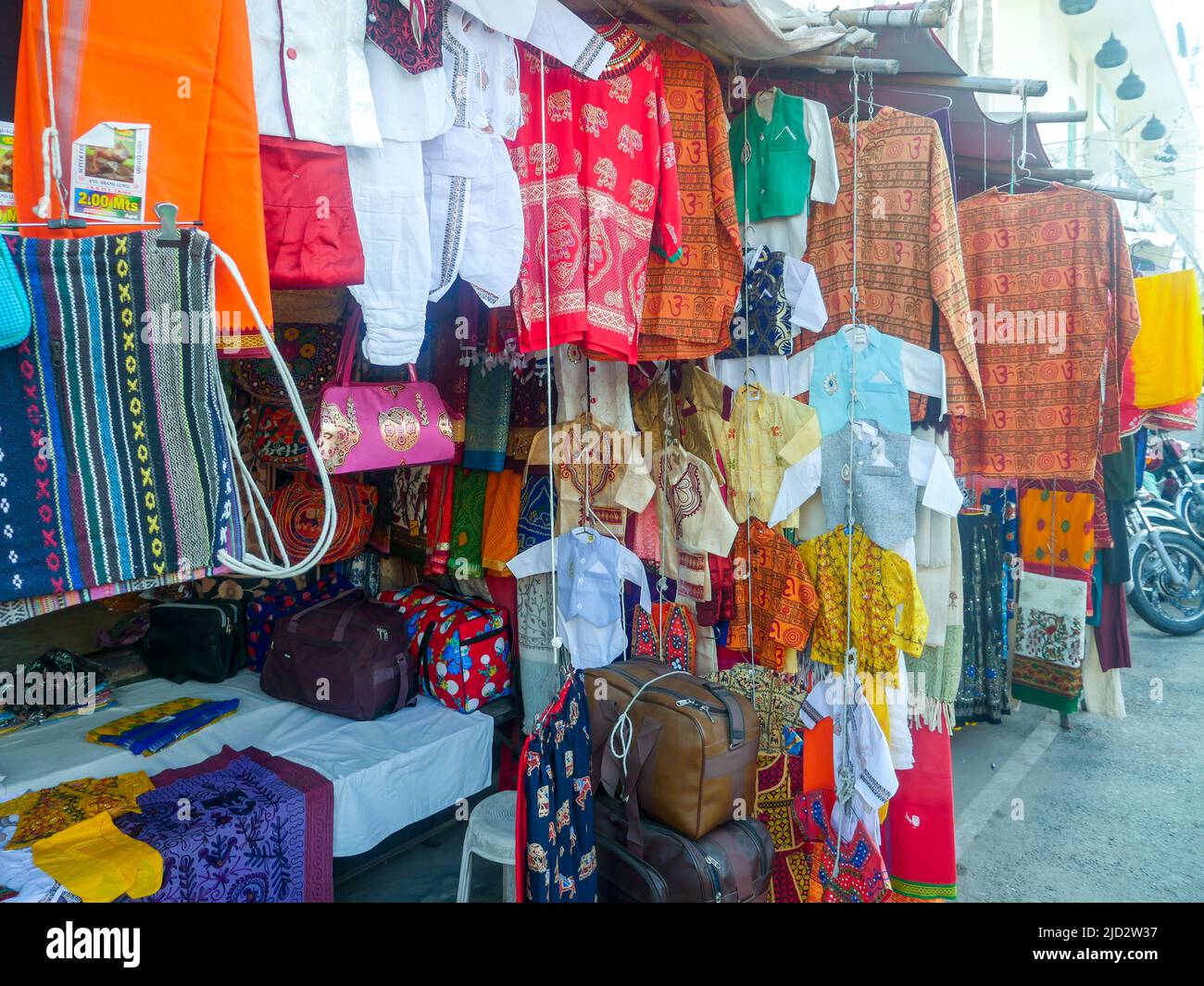Pushkar, Rajasthan India - November 4, 2019 : local street market selling cloths, t-shirts, dress and garments, menswear hanging in shop. Stock Photo