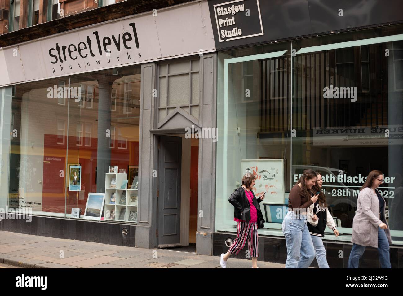 Rachel McDermott looking at photography in the Street Level Photoworks gallery, in the Trongate area of the City Centre, in Glasgow, Scotland, 10 April 2022.   N55°51.384' W4°14.830' Stock Photo