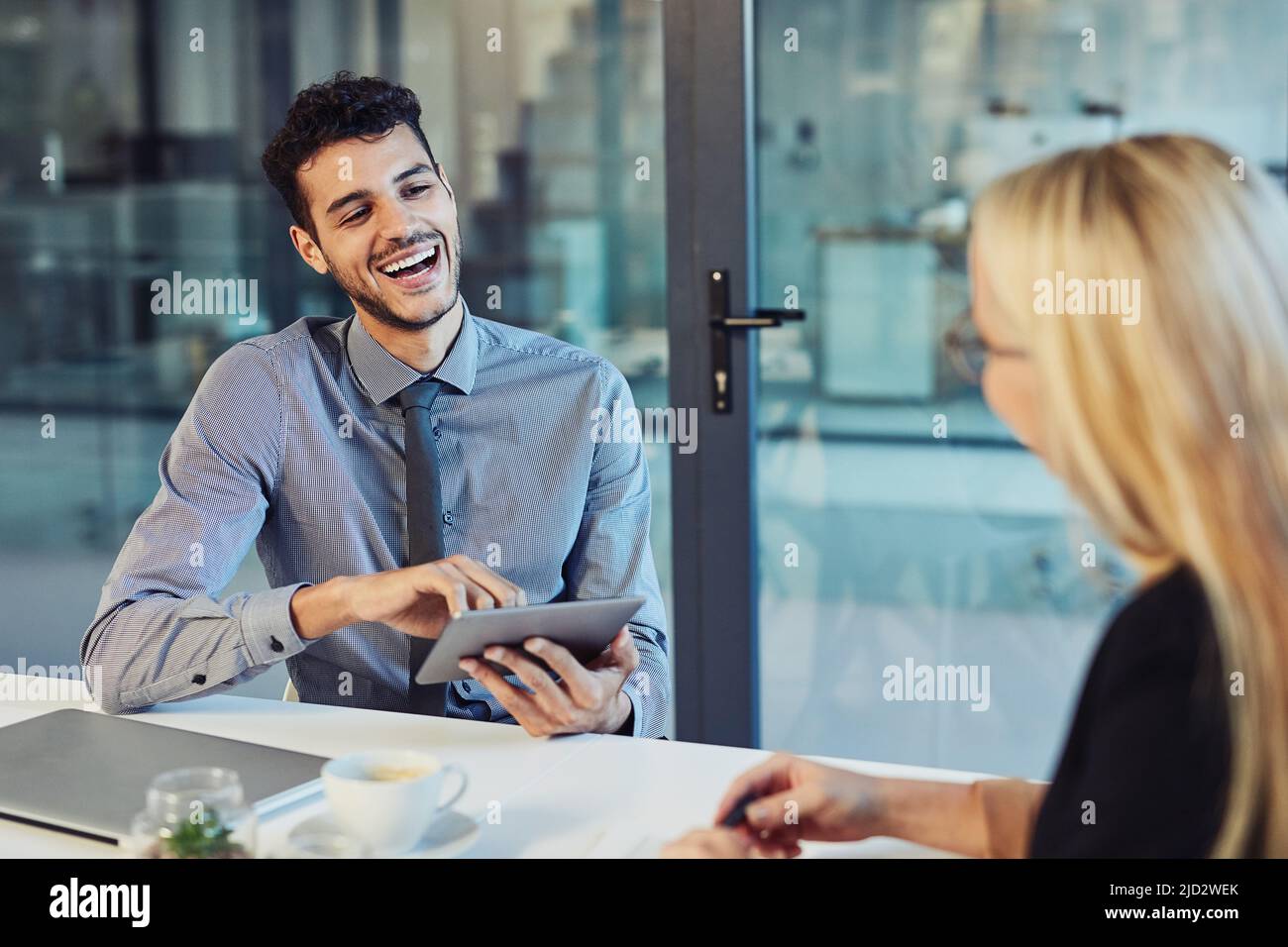 Team rapport, a must have for effective collaborations. Shot of a young businessman and businesswoman having a discussion in the boardroom of a modern Stock Photo
