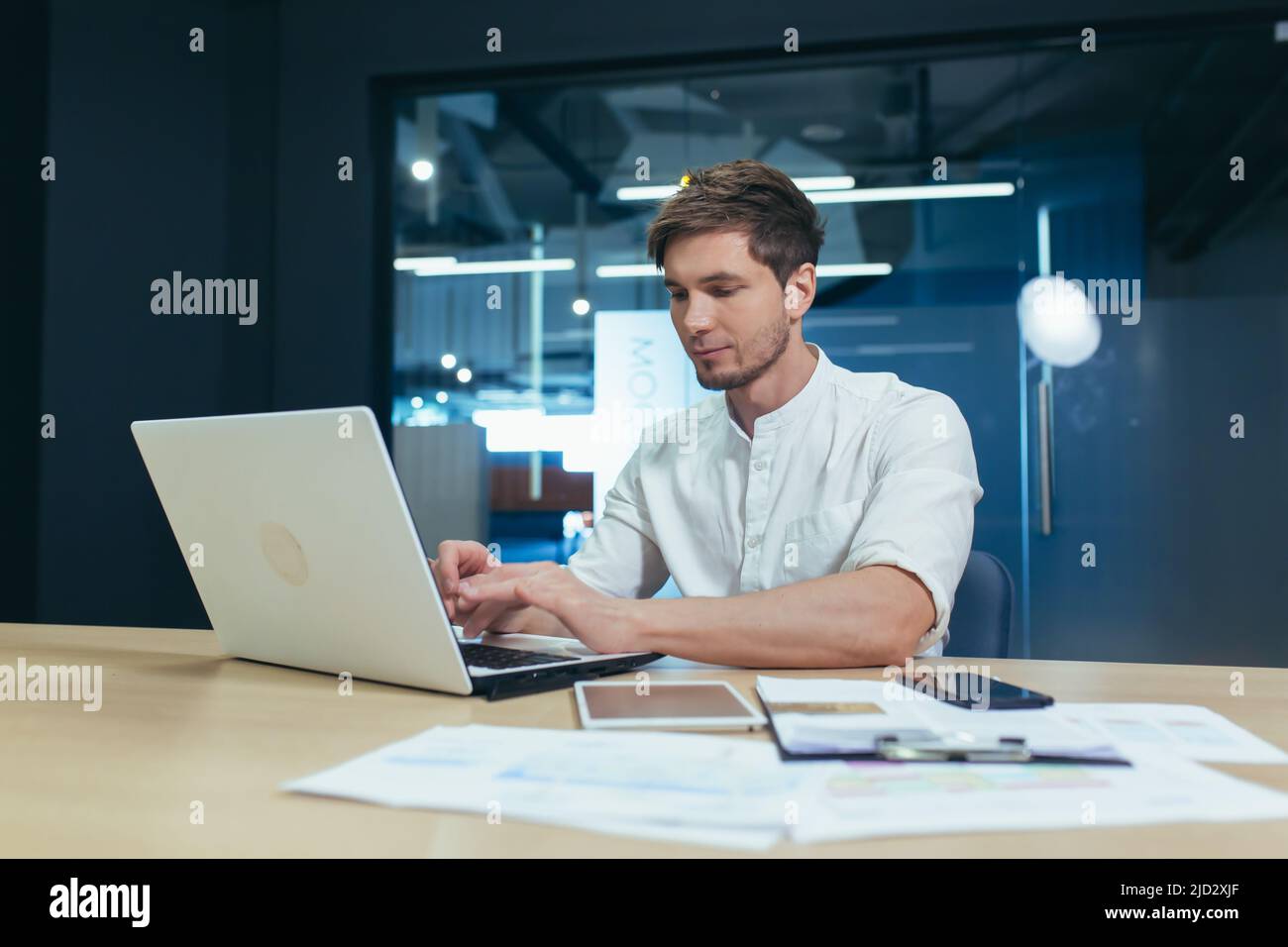 Serious young businessman working in the office on a laptop Stock Photo