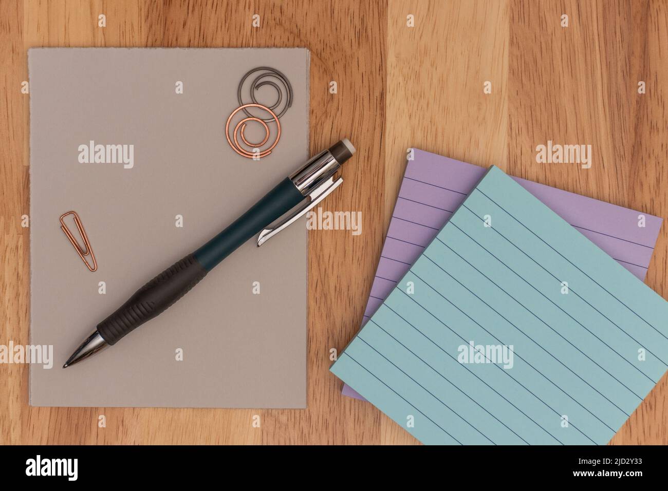 Administrative Professionals Day, Secretaries Day concept showing pencil, paper clips, and sticky notes on wooden surface Stock Photo
