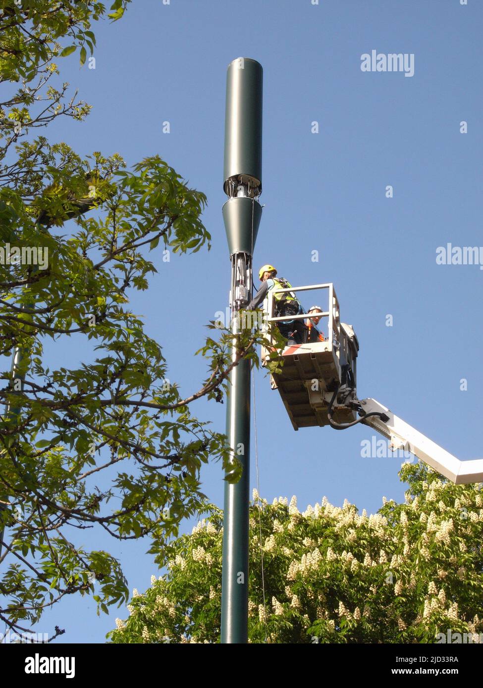 Workman using cherry picker while fitting a 5g Telecoms Mast London Stock Photo