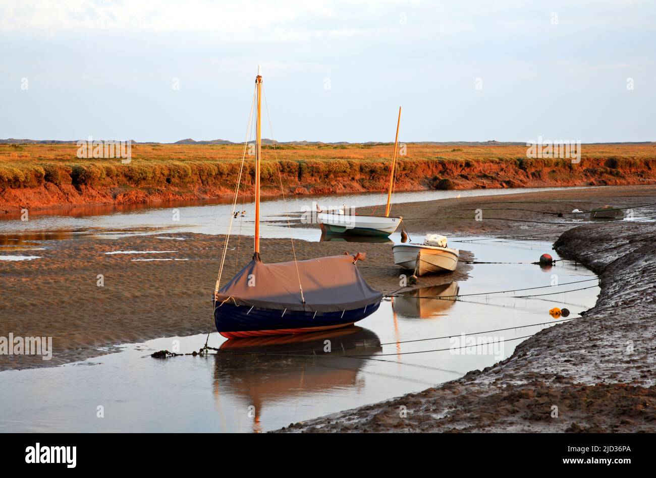 Three small leisure craft beached in Blakeney Channel at low water on the North Norfolk coast at Blakeney, Norfolk, England, United Kingdom.leisurevie Stock Photo