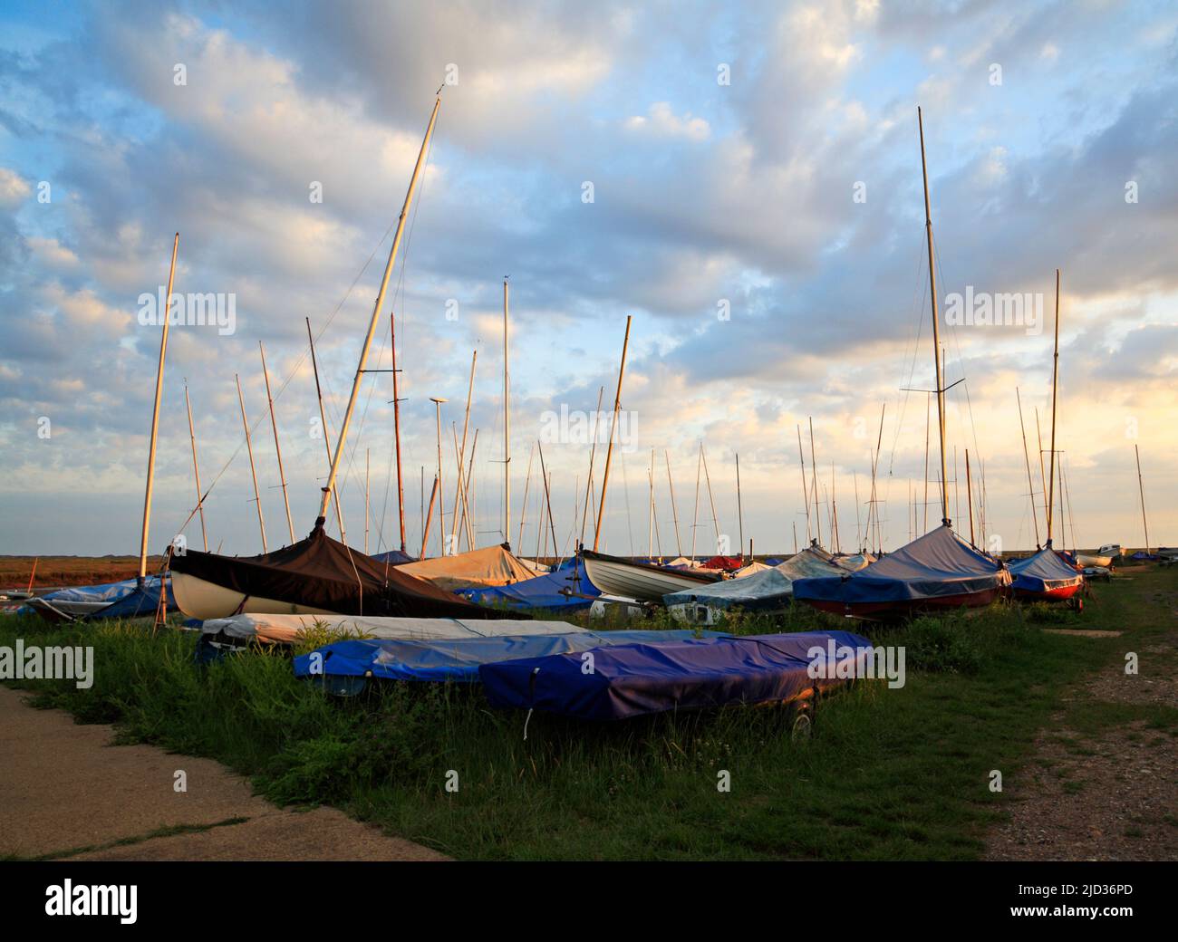 A group of sailboats with trailers parked by the tidal Blakeney Channel on the North Norfolk coast at Blakeney, Norfolk, England, United Kingdom.trave Stock Photo