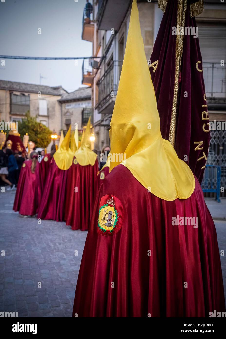 Cofrades in their traditional costumes with capirote, parading through the streets of Úbeda during Holy Week Stock Photo