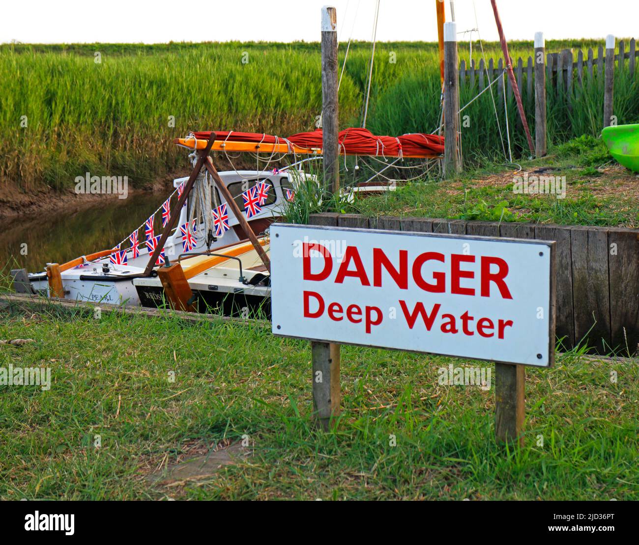 A Danger sign relating to deep water in the small restored harbour on the North Norfolk coast at Cley-next-the-Sea, Norfolk, England, United Kingdom. Stock Photo
