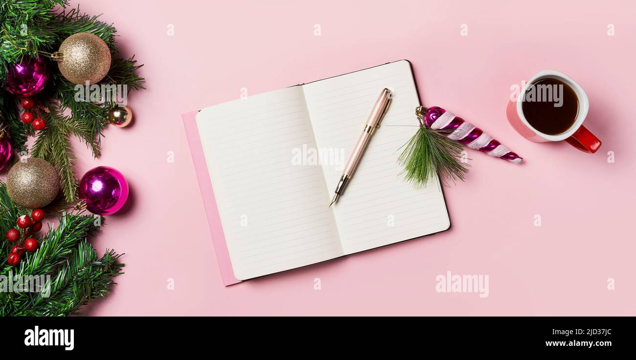 New Year background. Green fir branches with an open notebook and christmas decorations, coffee cup. Christmas workspace. Top view Stock Photo