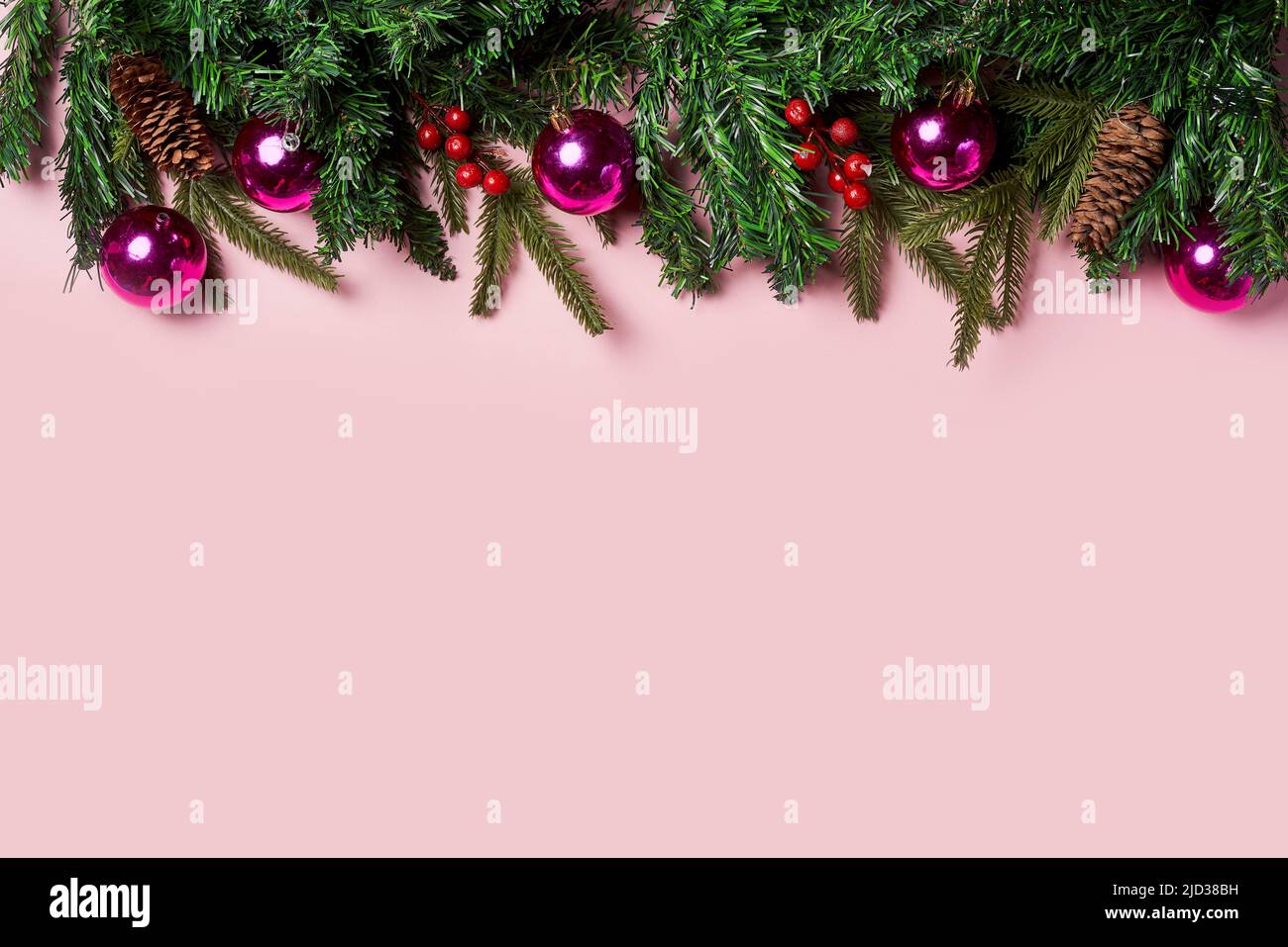 Christmas background with fir tree and decor on pink backgraund. Top view with copy space Stock Photo