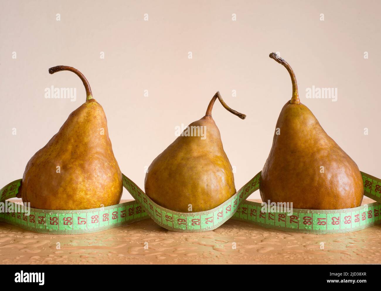 Front view of three pears with tape measure around its. Image made in studio using  natural window light.Image made with a full frame Nikon digital ca Stock Photo