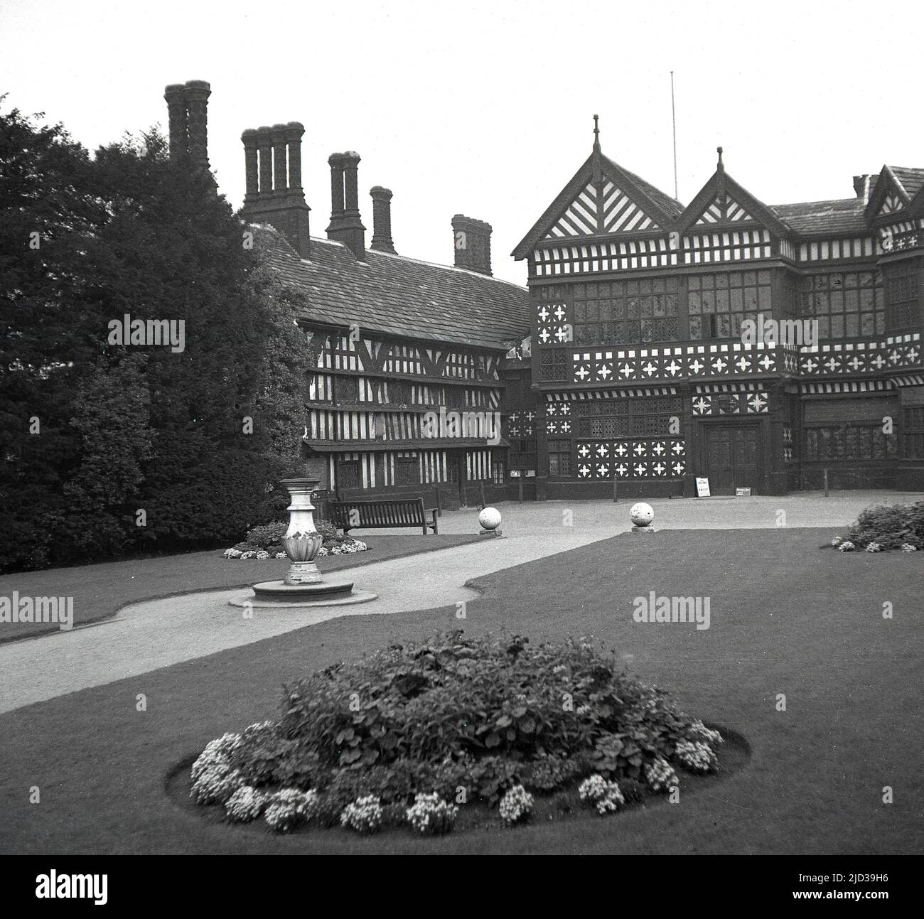 1940s, historical, the rear of Bramall Hall, Stockport, England, UK. A timber-framed Tudor manor house that dates back to the 14th century, with later additions, the house and surrounding parkland was acquired by the local authority in 1935 and became a museum. The Davenport family, which it is believed built the house, held the manor for over 500 years. Here we see a view from the 1940s from the west, of the main entrance, courtyard, south wing and the Great Hall in the centre. Stock Photo