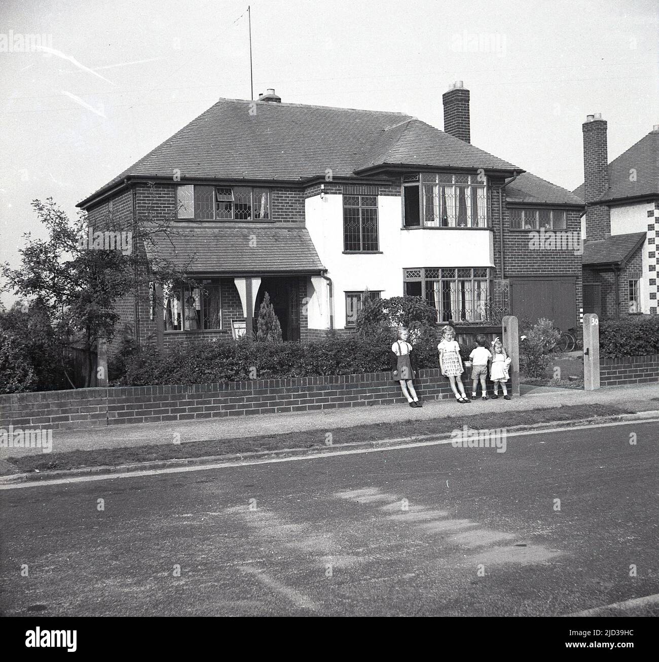 1950s, historical, four young children on the pavement outside a large