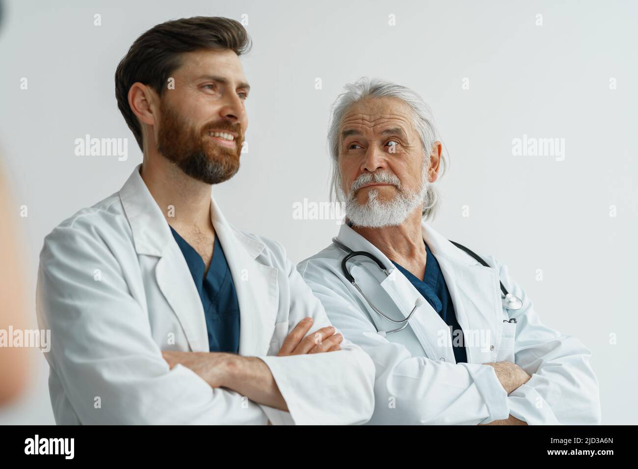 Doctors In Uniform Two professional doctors in uniform standing in hospital with crossing ...