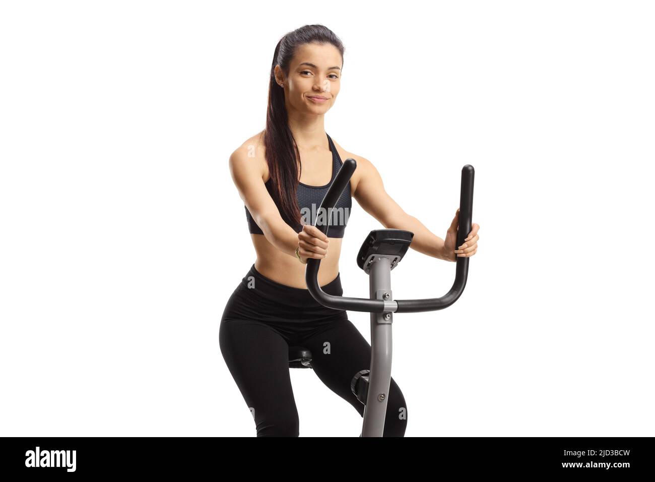 Young female exercising on a stationary bike isolated on white background Stock Photo