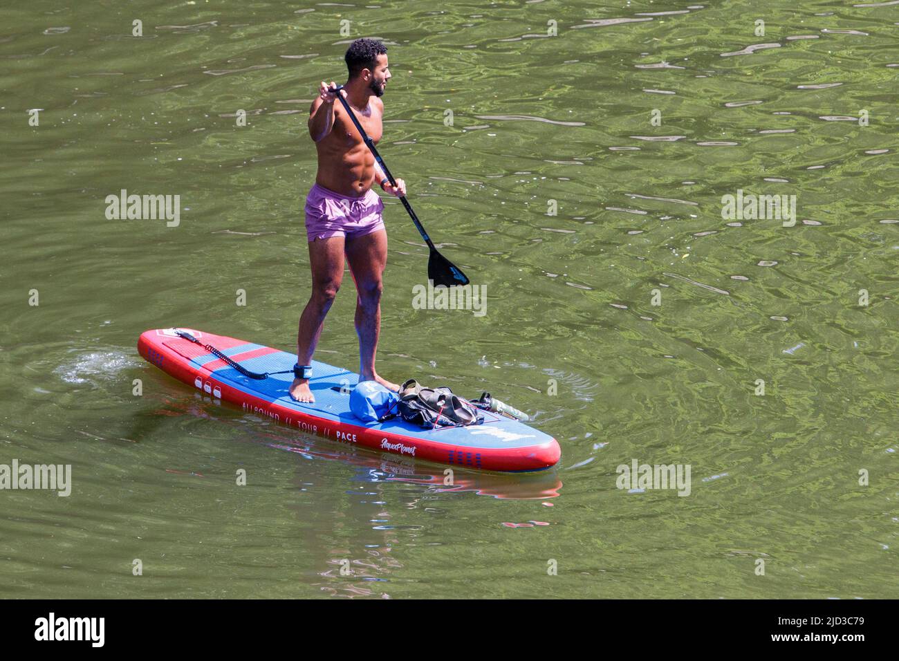 Bath, UK, 17th June, 2022. With many parts of the UK enjoying another very hot and sunny day, a paddleboarder is pictured enjoying the hot weather on the River Avon in front of Pulteney Bridge.  Credit: Lynchpics/Alamy Live News Stock Photo