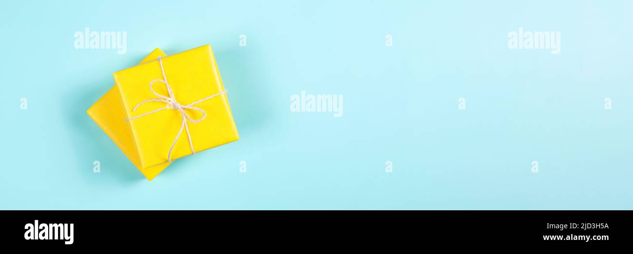 Two yellow gift boxes on blue background. Banner for website. Stock Photo