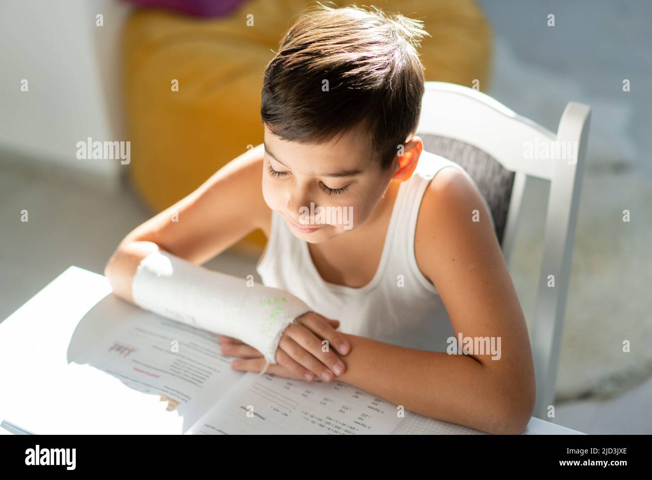 Back to school. Thinking child boy writing, drawing in notebook sitting at desk and doing homework. High quality photo Stock Photo