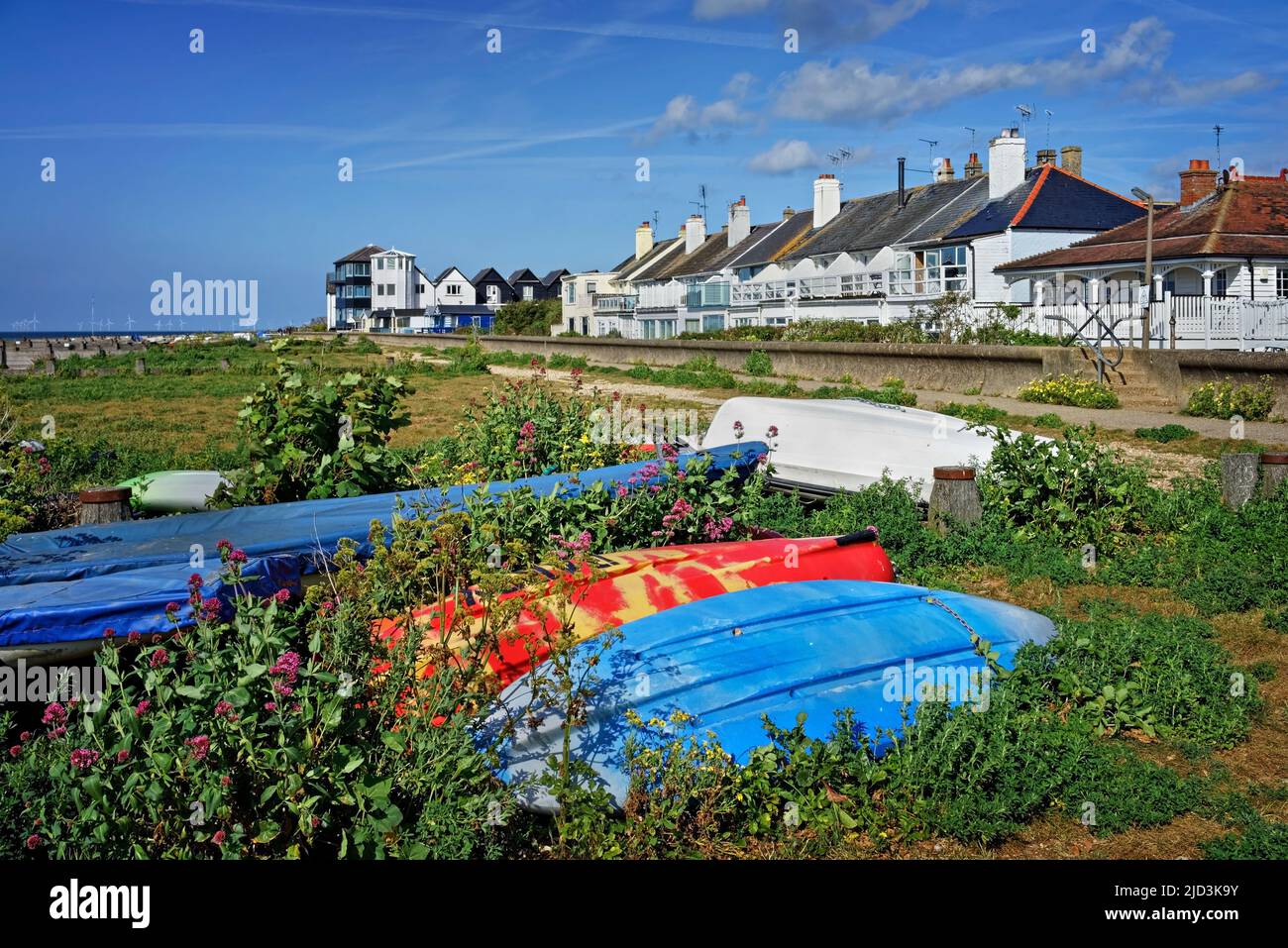 UK, Kent, Whitstable Beach Huts, Overturned Boats and Apartments Stock Photo