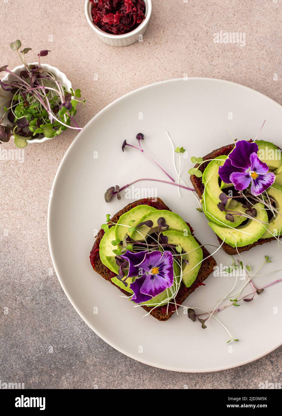 Sandwiches with boiled beetroot and avocado with microgreens, delicious healthy breakfast Stock Photo